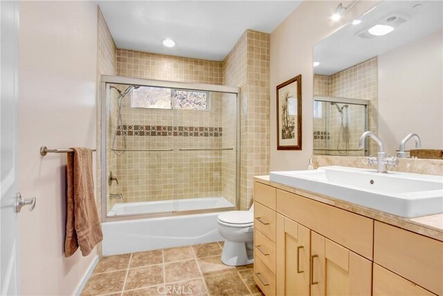 full bathroom featuring vanity, tile patterned floors, enclosed tub / shower combo, and toilet