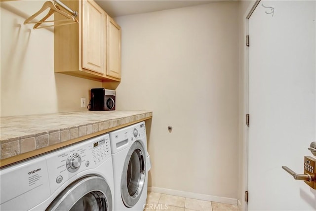 laundry room with washing machine and dryer, cabinet space, baseboards, and light tile patterned floors