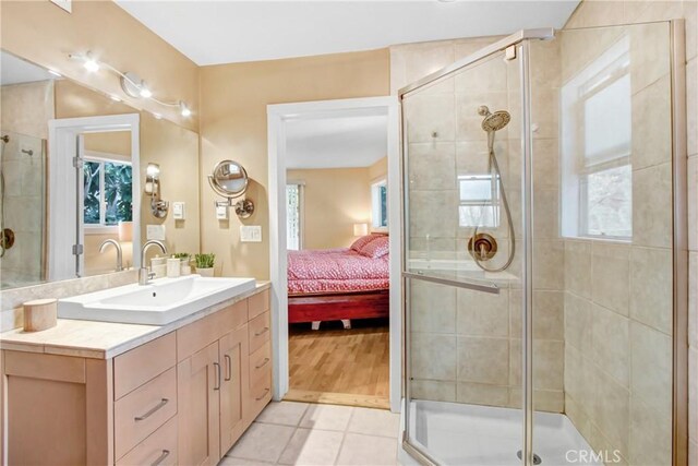 bathroom with tile patterned flooring, vanity, and walk in shower