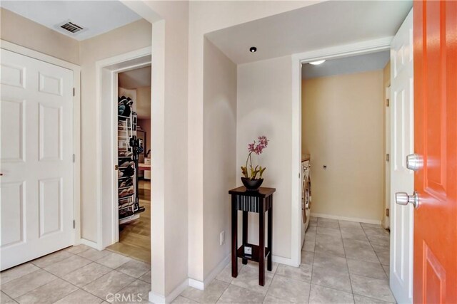 entryway with light tile patterned floors and washer and clothes dryer