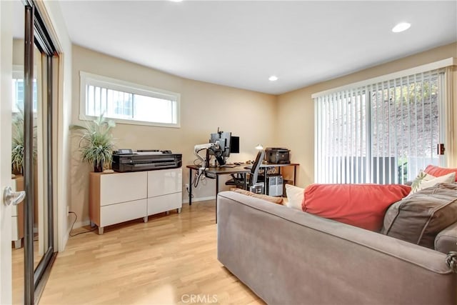 living room featuring light wood-style floors, baseboards, and recessed lighting