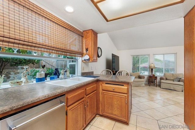 kitchen with lofted ceiling, sink, dishwasher, light tile patterned flooring, and kitchen peninsula