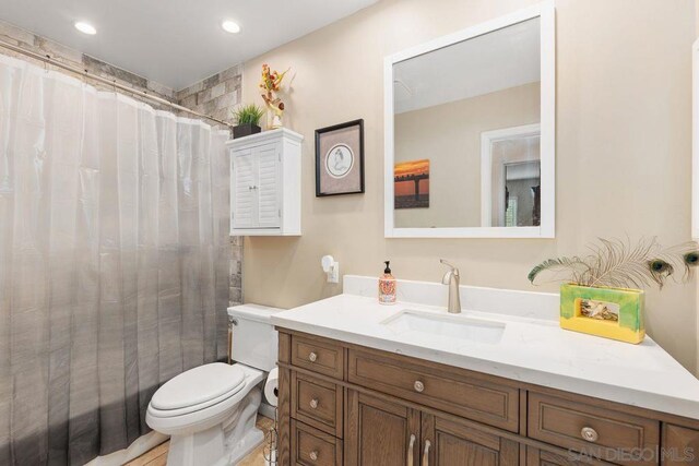 bathroom featuring vanity, curtained shower, and toilet