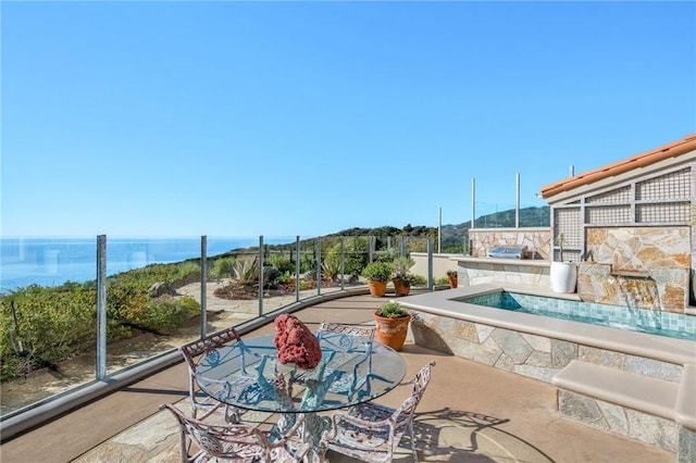 view of pool with a patio and a water view