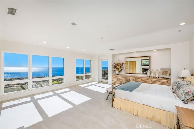 bedroom with a water view and light colored carpet