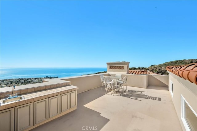 view of patio featuring a water view and sink