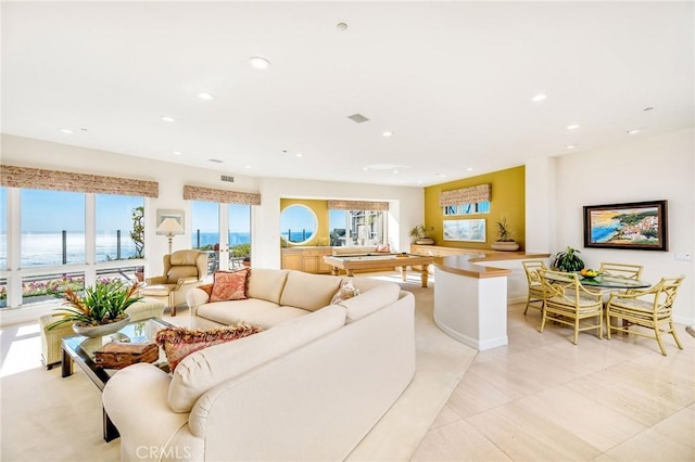 tiled living room featuring a water view and french doors