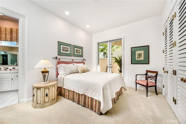 bedroom with french doors, light colored carpet, connected bathroom, and access to exterior