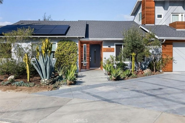 view of front facade featuring a garage and solar panels