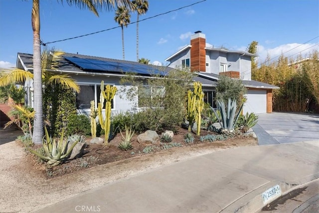 view of front facade with a garage and solar panels