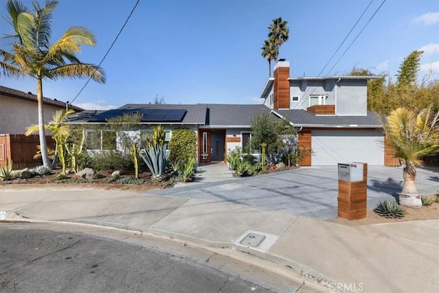 view of front of house featuring a garage and solar panels