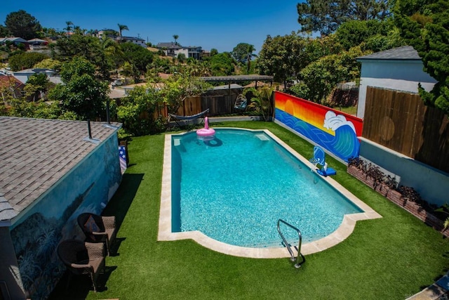 view of pool with a yard