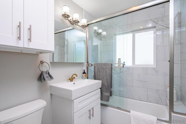 full bathroom with vanity, toilet, and combined bath / shower with glass door