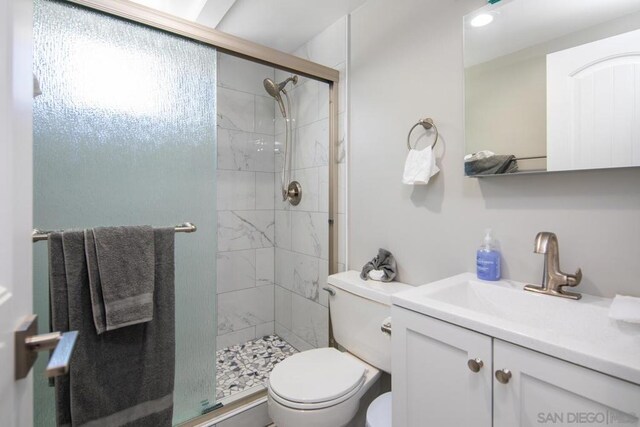 bathroom featuring vanity, toilet, and an enclosed shower