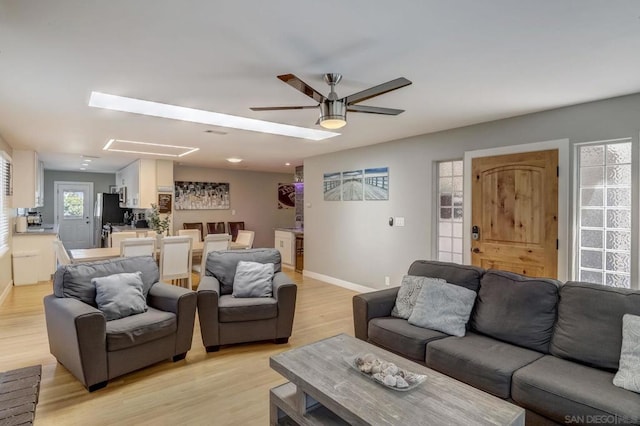 living room with ceiling fan and light hardwood / wood-style floors