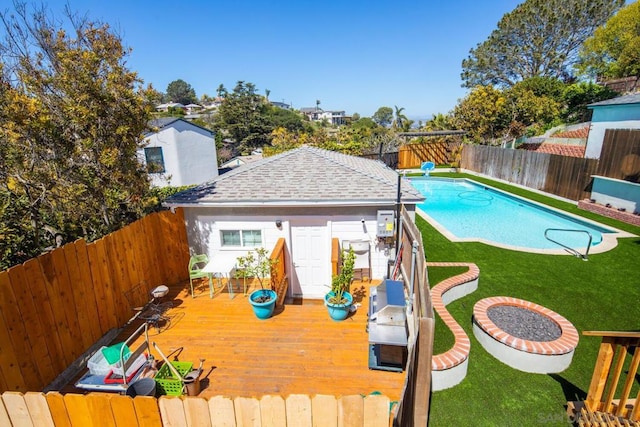 view of pool with an outbuilding, a yard, and a wooden deck