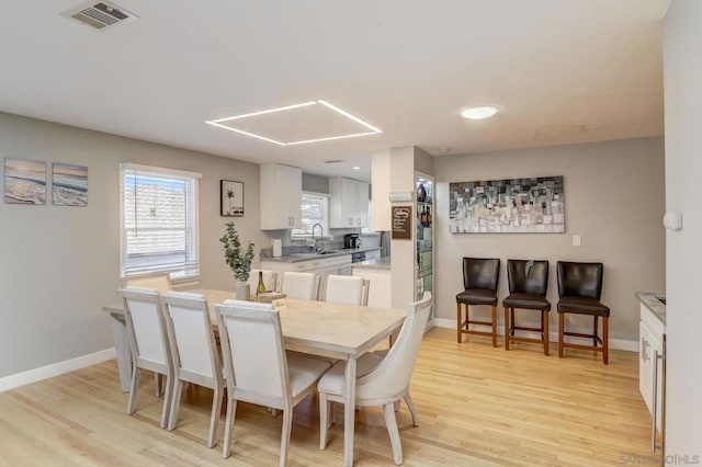 dining space featuring sink and light hardwood / wood-style flooring