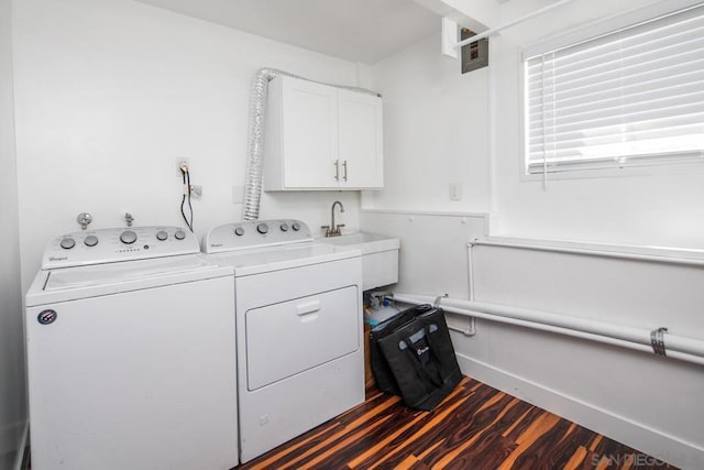 washroom featuring dark hardwood / wood-style floors, washer and clothes dryer, and cabinets