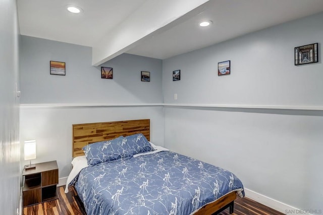 bedroom with hardwood / wood-style flooring and beam ceiling