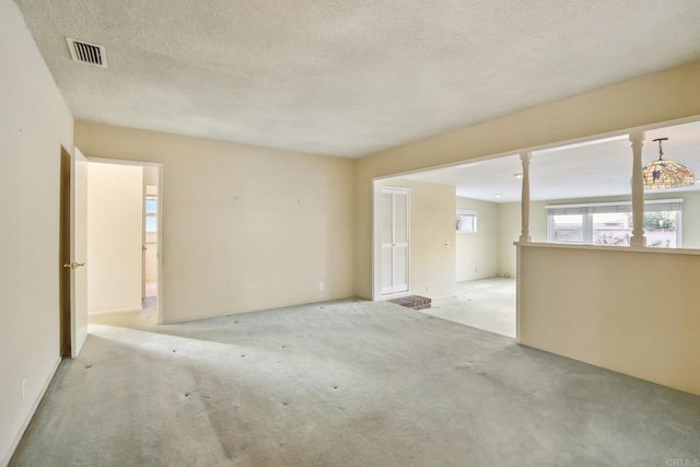 unfurnished room featuring light carpet and a textured ceiling