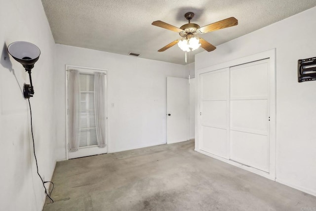 unfurnished bedroom featuring ceiling fan, a textured ceiling, and a closet