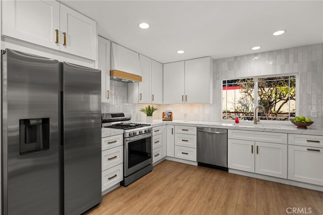 kitchen featuring white cabinetry, appliances with stainless steel finishes, light hardwood / wood-style floors, and sink