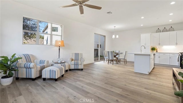 living room featuring ceiling fan and light hardwood / wood-style flooring