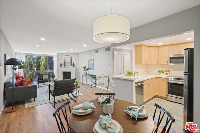 dining space with sink and light hardwood / wood-style floors