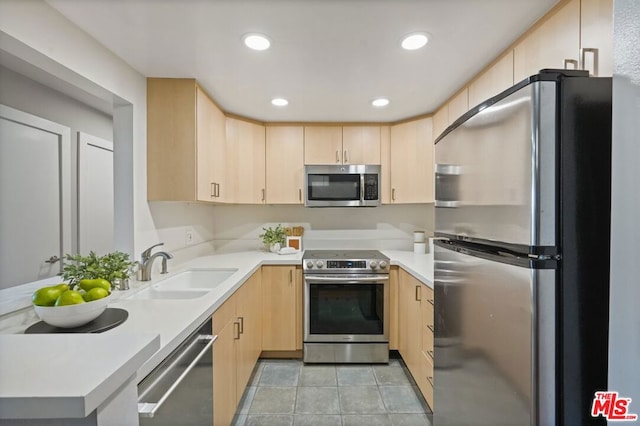 kitchen featuring stainless steel appliances, sink, and light brown cabinets