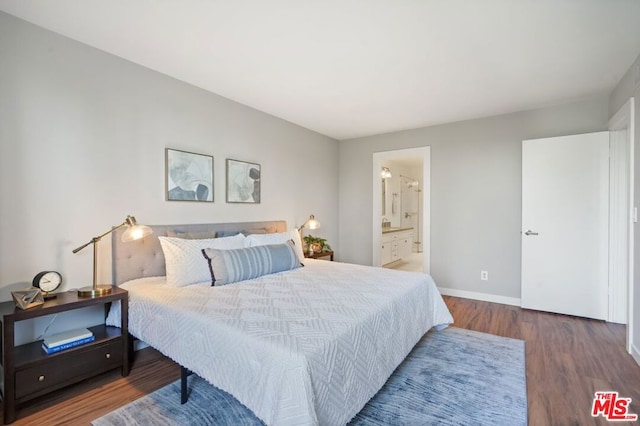 bedroom featuring ensuite bathroom and dark hardwood / wood-style flooring