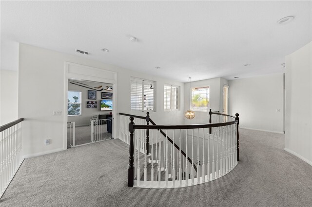 corridor featuring light colored carpet