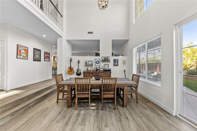 dining space with a chandelier, a healthy amount of sunlight, and light wood-type flooring