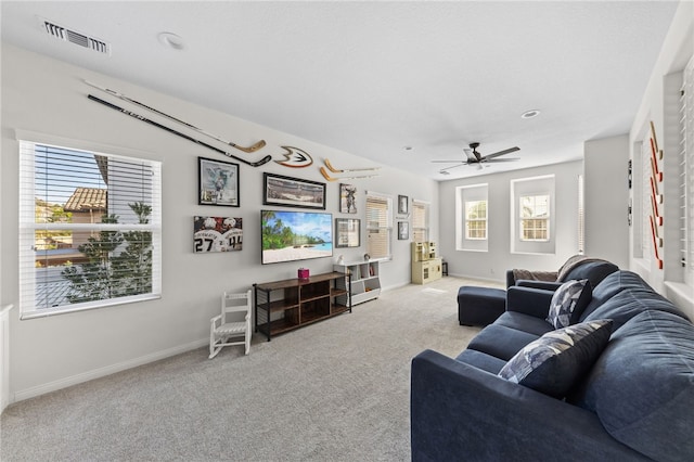 carpeted living room with ceiling fan