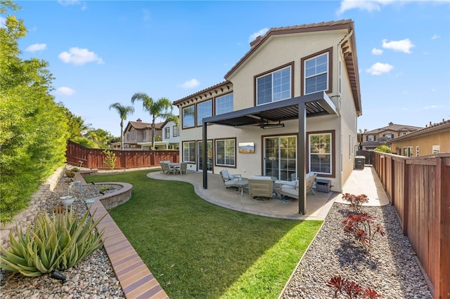 back of house featuring an outdoor living space, a patio area, ceiling fan, and a lawn