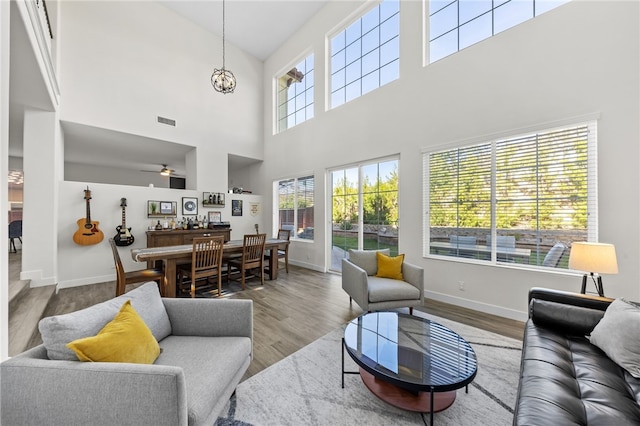 living room with hardwood / wood-style flooring and ceiling fan with notable chandelier