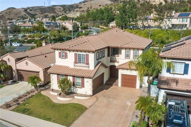 view of front of property with a garage, a mountain view, and a front lawn