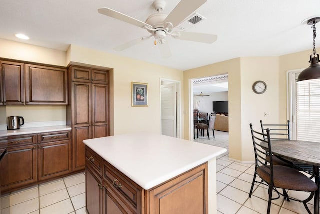 kitchen featuring light tile patterned flooring, ceiling fan, decorative light fixtures, and a center island