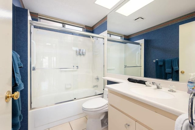 full bathroom featuring bath / shower combo with glass door, vanity, ornamental molding, tile patterned floors, and toilet