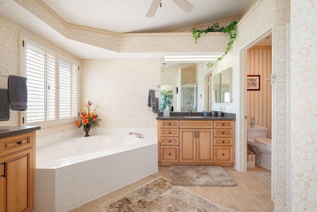 full bathroom featuring toilet, shower with separate bathtub, vanity, ceiling fan, and tile patterned flooring