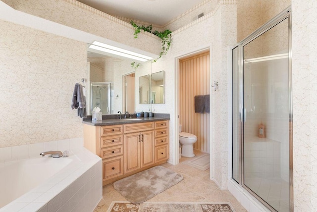 full bathroom featuring independent shower and bath, vanity, and toilet