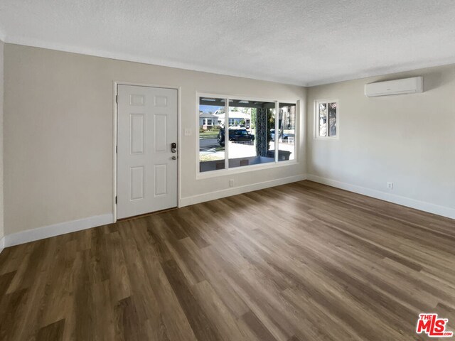 entryway featuring a wall mounted AC, a textured ceiling, and dark hardwood / wood-style flooring