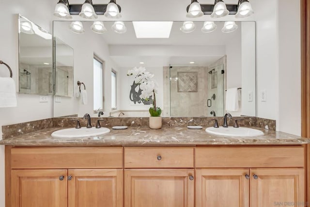 bathroom with vanity, a skylight, and a shower with shower door