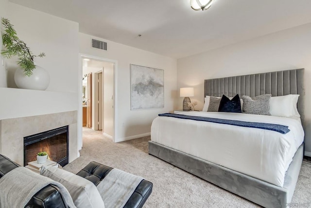 carpeted bedroom featuring a tiled fireplace