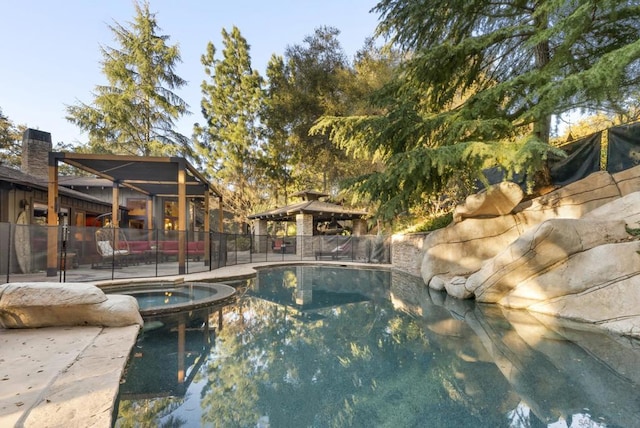 view of swimming pool featuring a gazebo and an in ground hot tub