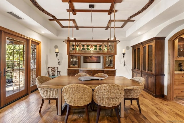 dining space featuring a raised ceiling and wood-type flooring