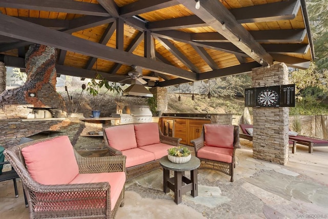 view of patio / terrace with a gazebo, area for grilling, ceiling fan, an outdoor living space with a fireplace, and exterior kitchen