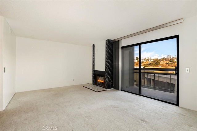 unfurnished living room featuring a large fireplace and carpet