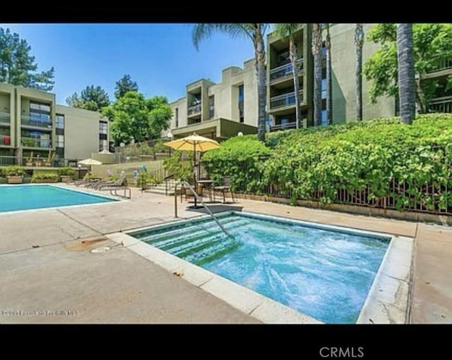 pool with fence and a patio area