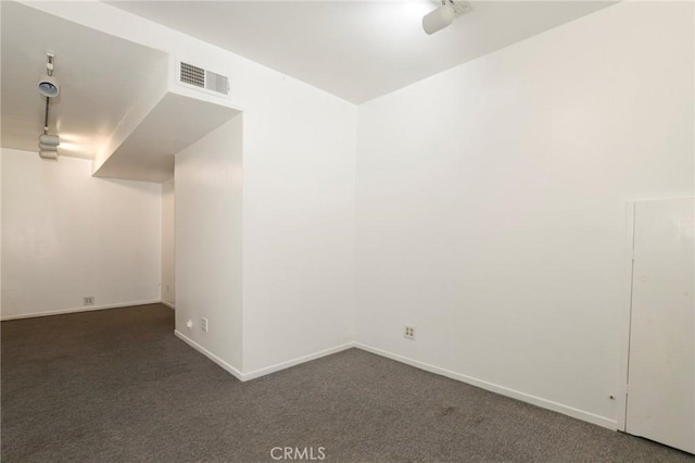 unfurnished room featuring dark carpet