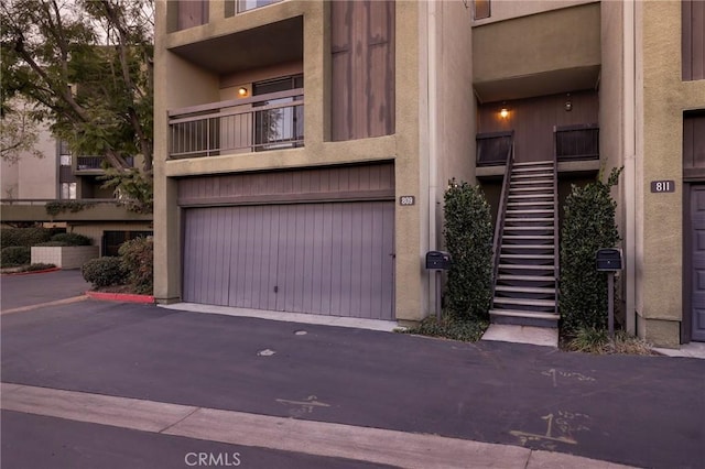 exterior space featuring stairs, a garage, and driveway